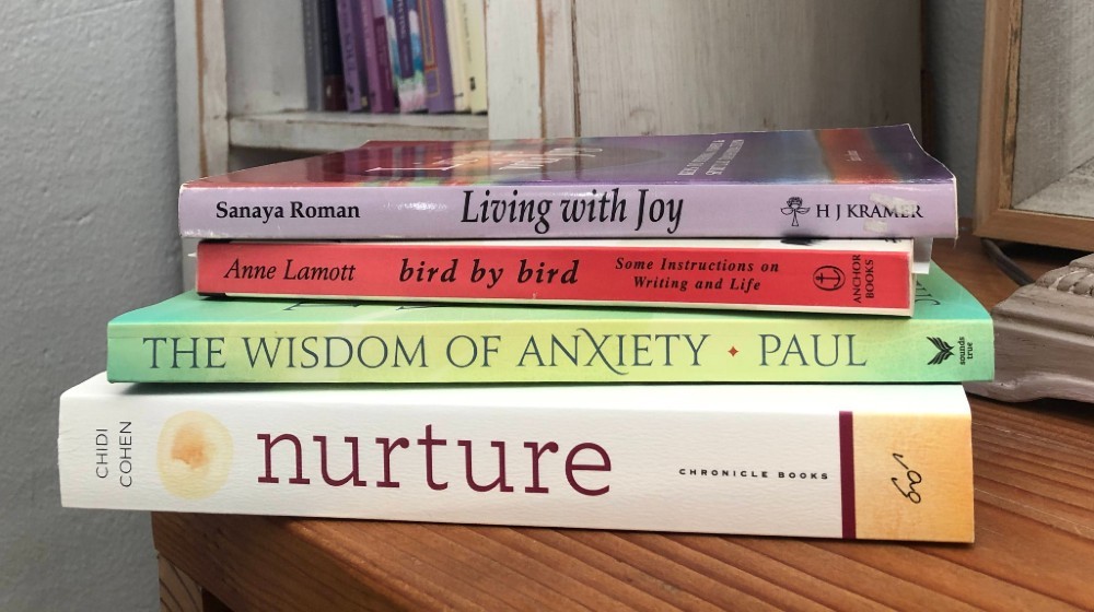 Stack of personal growth books on nightstand